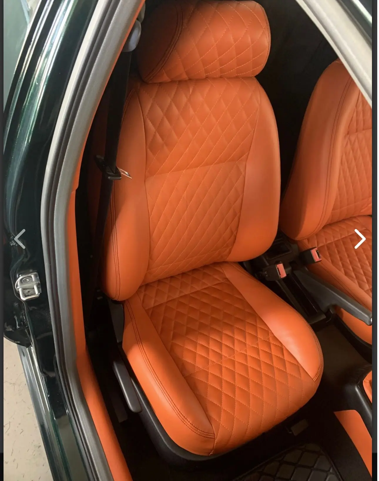 Bilstol i skinn med orange diamantsöm, sedd från sidan